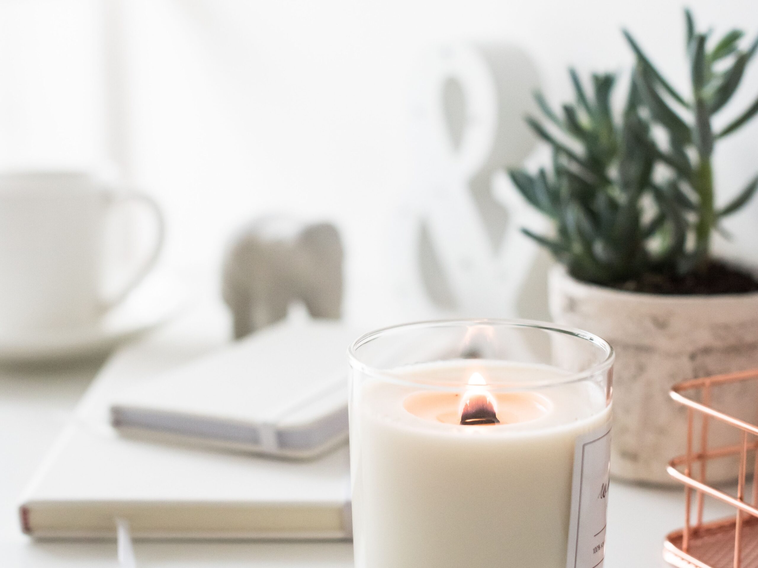 A white candle in a glass jar.