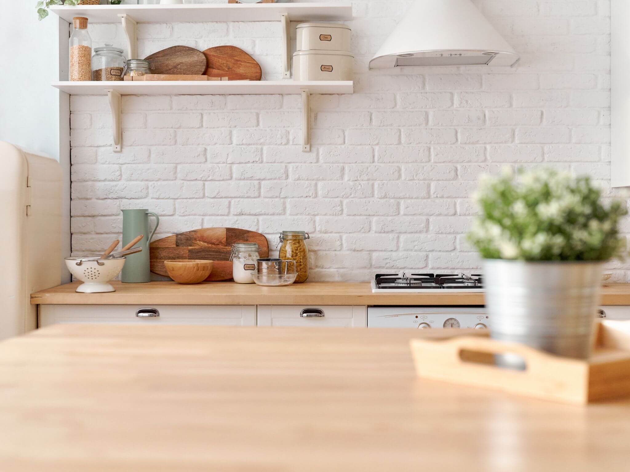 A farmhouse style kitchen with white metro tiles and wooden worktops.